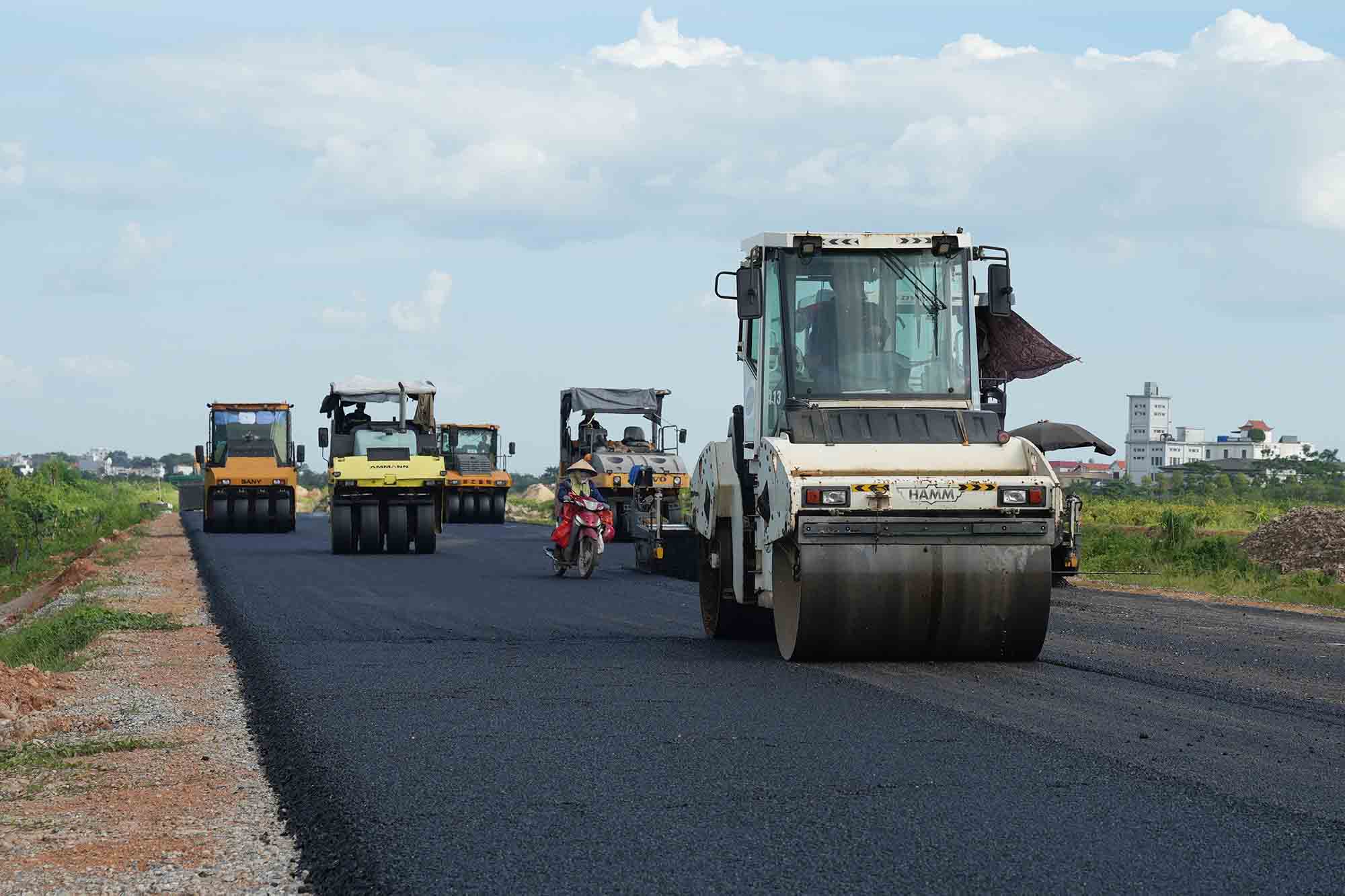 노동자들은 햇볕을 쬐며 수도권 4차 순환 도로 프로젝트 진행 속도 경쟁의 정점에 있습니다