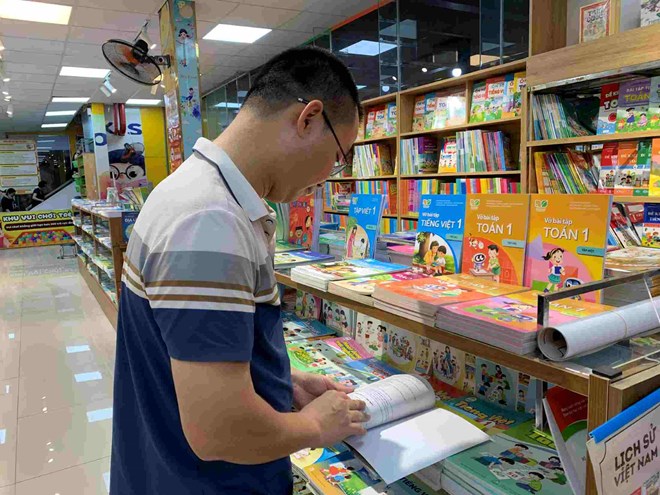 Anh Pham Van Thang chon sach giao khoa cho con chuan bi len lop 2. Anh: Thanh Hang 