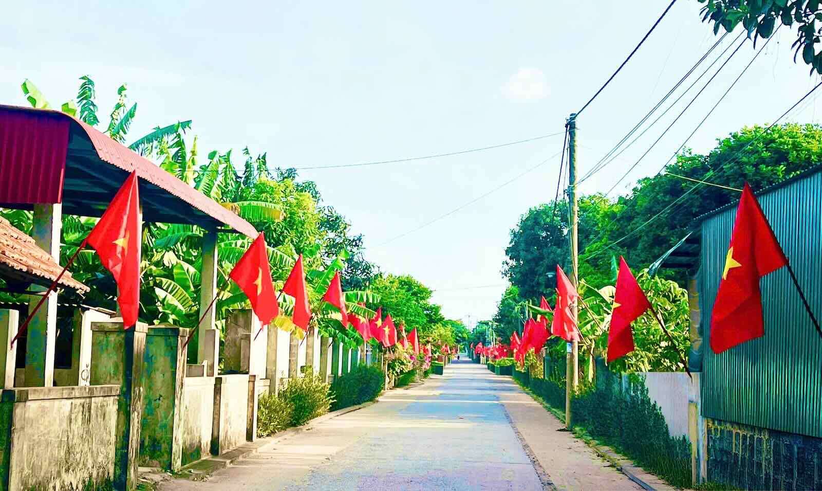 Bandera roja con estrella dorada en la carretera en la comuna de Hoa Trach. Foto: Nguyen Hoai