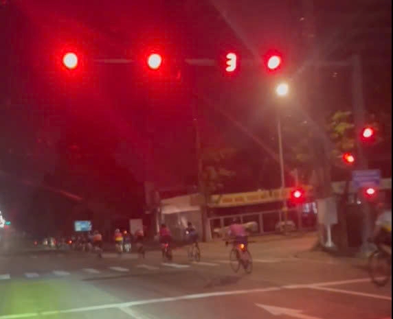 Khoang 20 nguoi di xe dap vuot den do tren duong My Phuoc Tan Van. Anh cat tu clip nguoi dan cung cap