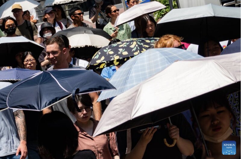 2024년 7월 4일 일본 도쿄 버스의 뜨거운 거리를 걷는 사람들. 사진: 신화통신