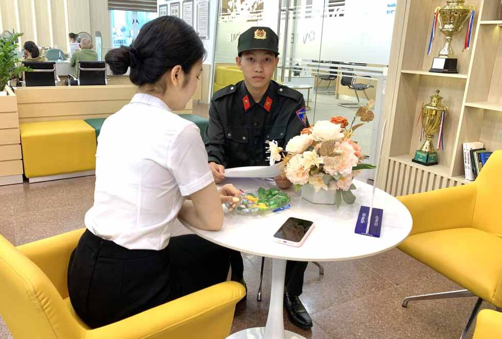 El soldado Hoai realiza los tramites para transferir y devolver 30 millones de VND a la persona que los transfirio por error. Foto: Policia de Ha Tinh.