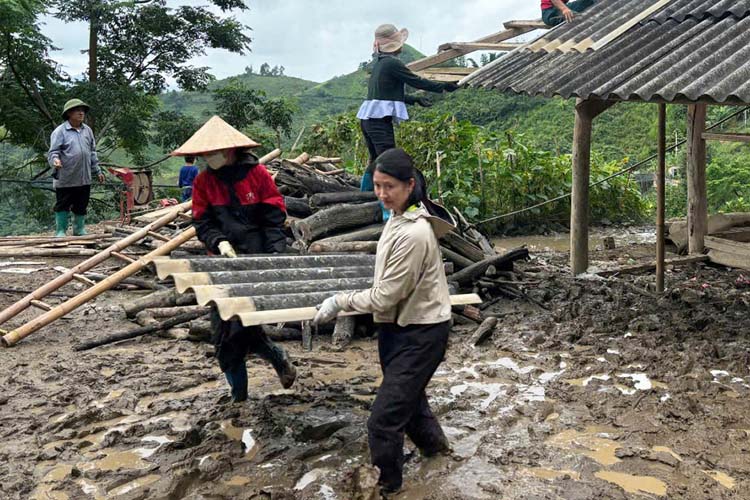 Profesores de la guarderia Ban Mai en la comuna de Xa Dung provincia de Dien Bien ayudan a los hogares dañados con casas en la aldea de Tham My B. Foto: Quang Sinh