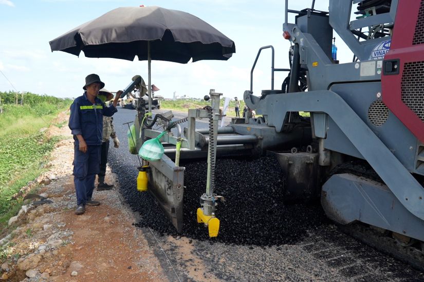 노동자들이 하노이 Duong Hoa tang 면을 통과하는 4차 순환 도로 병행 도로 아스팔트 포장 항목을 시공하고 있습니다. 사진: Huu Chanh