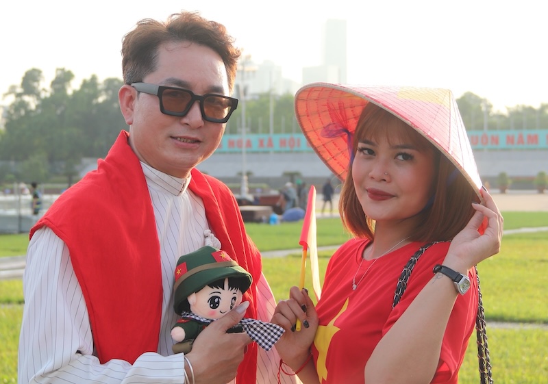 Anh Hoang Hoang, mot du khach tu TP Ho Chi Minh, lua chon trang phuc ao dai, non la de chup hinh cung nguoi than cua minh. Anh: Nguyen Linh