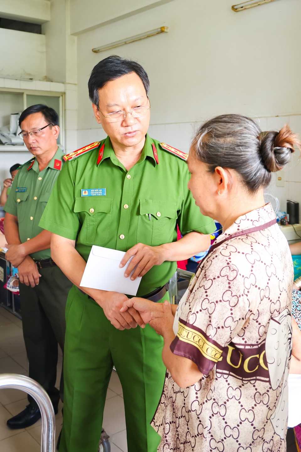 Dai ta Bui Duc An - Pho Giam doc Cong an TP trao phan qua ho tro cho gia dinh dong chi Bui Tan Tai. Anh: Cong an Can Tho