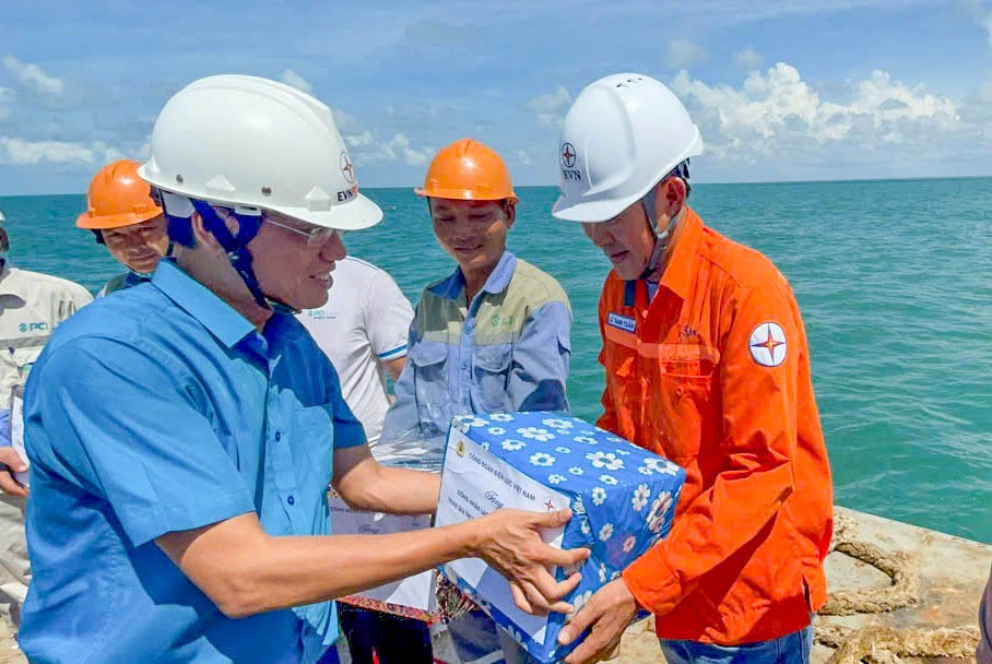 Doan cong tac trao qua cho cong nhan thi cong. Anh: Don vi cung cap