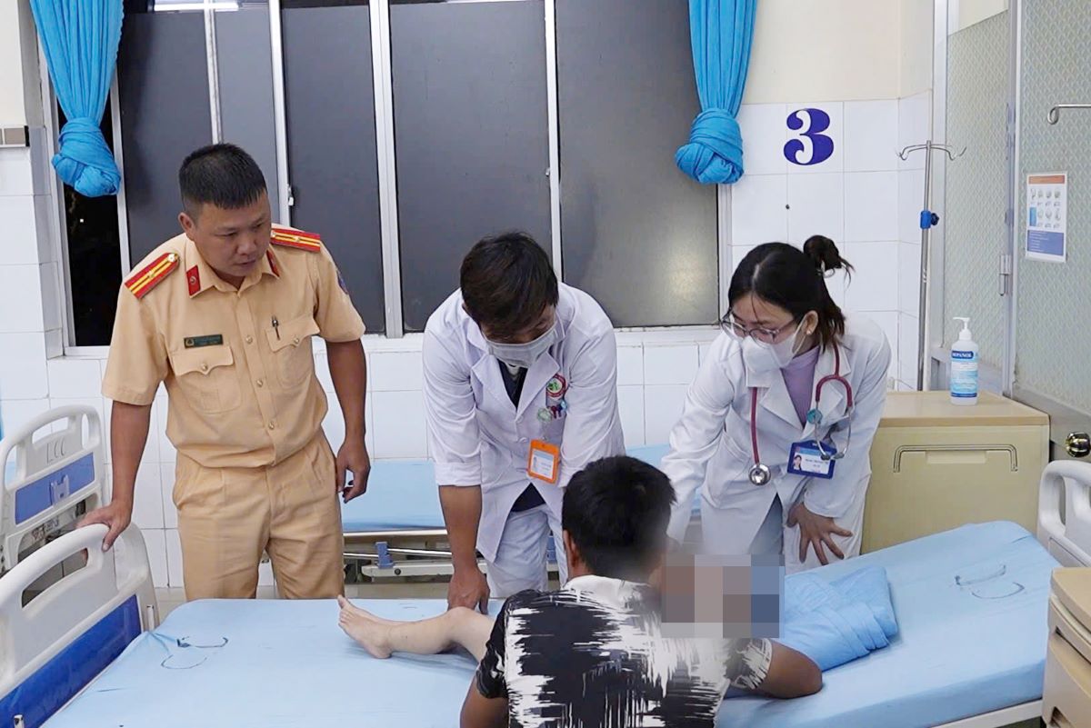 Canh sat giao thong Lam Dong ho tro gia dinh du khach dua chau be den benh vien cap cuu. Anh: Cong an
