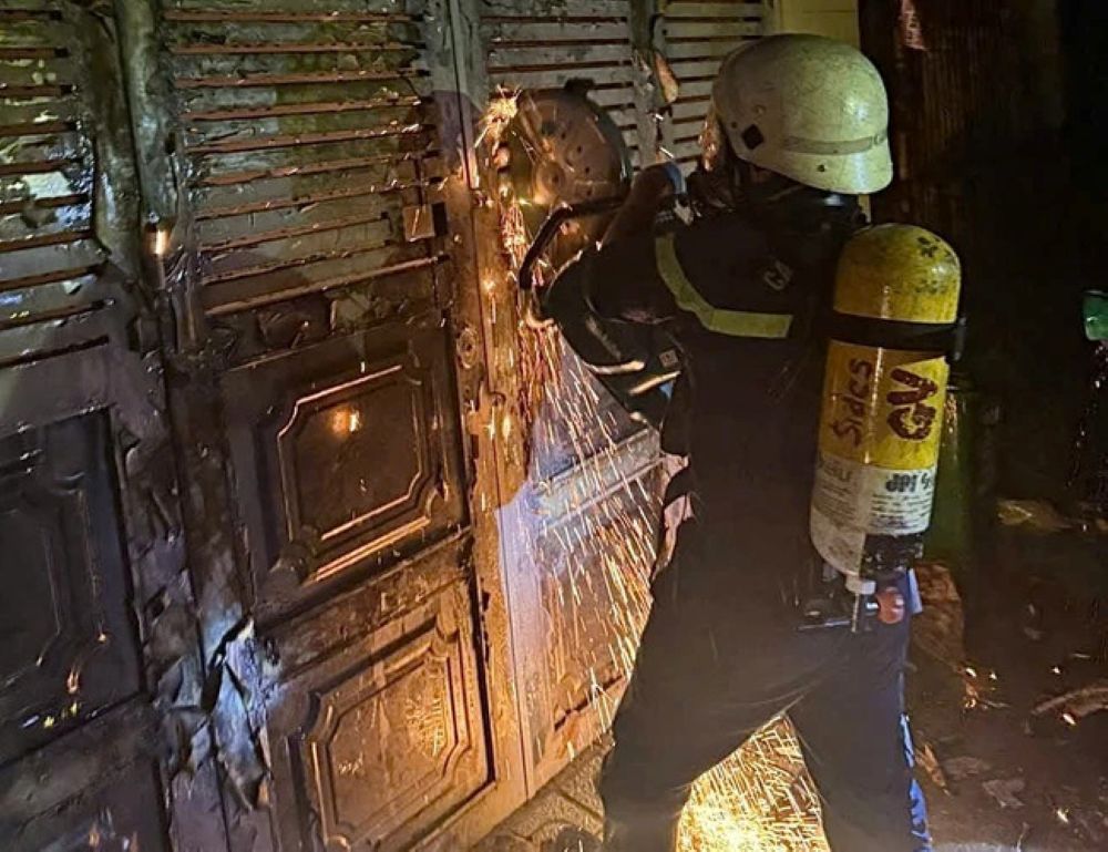 消防隊は消火と救助のためにドアを壊そうとしています。写真:Dong Hoang