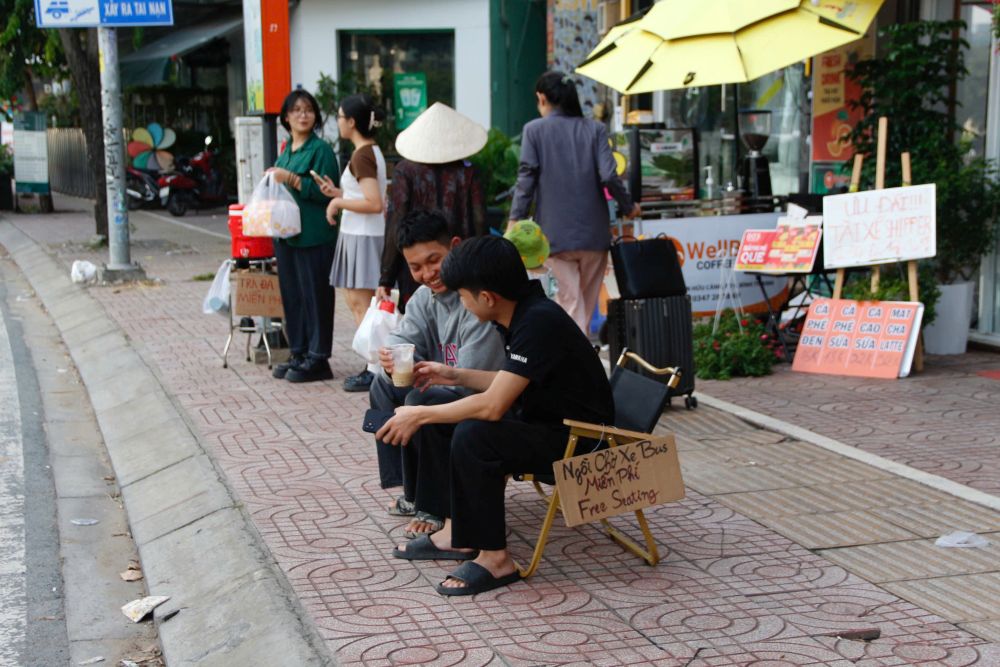 Nguoi dan den ngoi cho xe buyt. Anh: Thai Bao