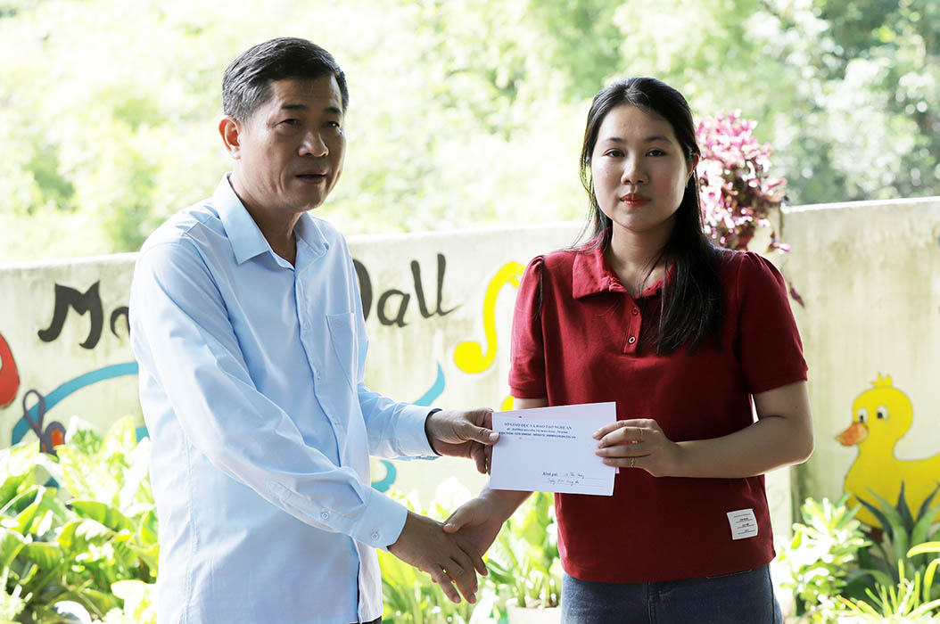 Giam doc So Giao duc va Dao tao Nghe An Thai Van Thanh trao ho tro cho giao vien khac phuc hau qua mua lu. Anh: Quoc Huy