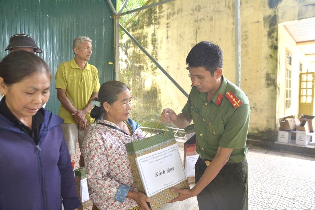 Nhung mon qua thiet thuc duoc can bo Phong An ninh Kinh te Cong an tinh Nghe An trao tan tay ba con vung lu. Anh: Quynh Trang