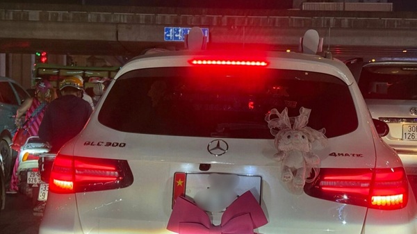  Cảnh sát giao thông đang tiến hành xác minh ô tô nhãn hiệu Mercedes có hành vi dán nơ che khuất một phần biển số. Ảnh: CSGT