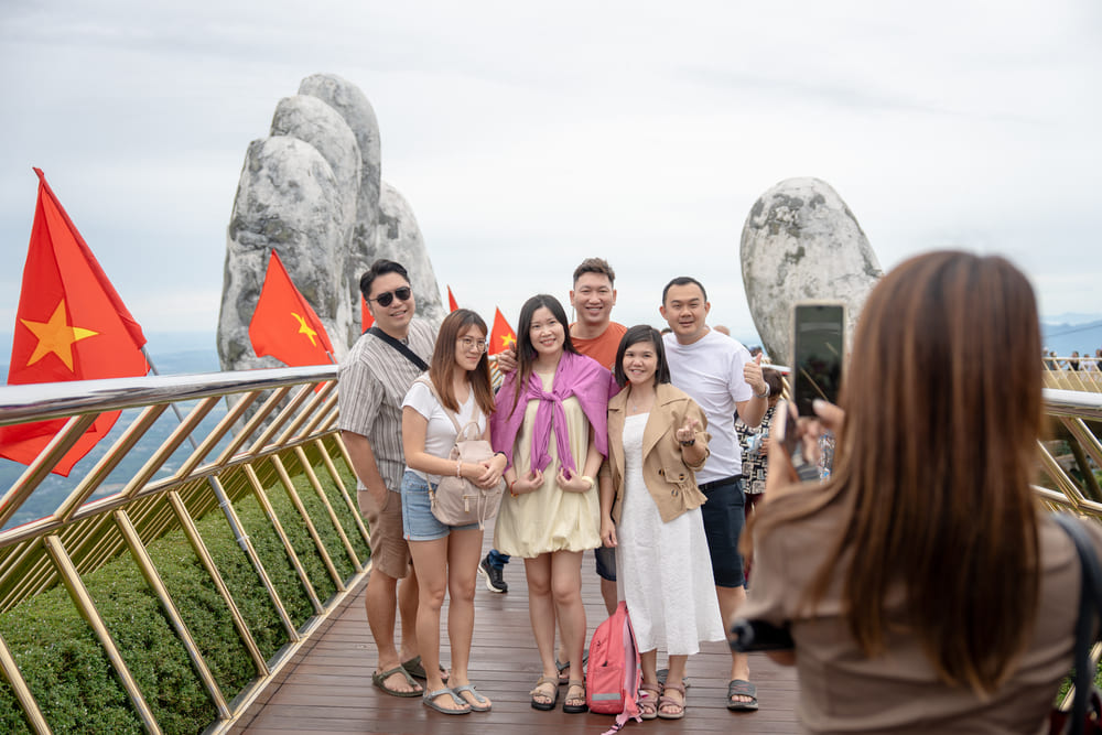 International tourists enjoy taking photos of memorabilia in Ba Na decorated with the brilliant red flag with yellow star. Photo: Thanh Son