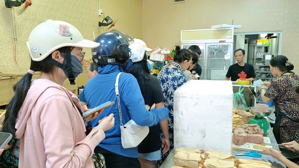 Tourists are rushing to buy spicy bread and sticky rice in the Hai Phong vegetable market. Photo: Mai Dung