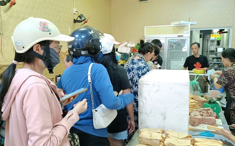 Tourists are rushing to buy spicy bread and sticky rice in the Hai Phong vegetable market. Photo: Mai Dung