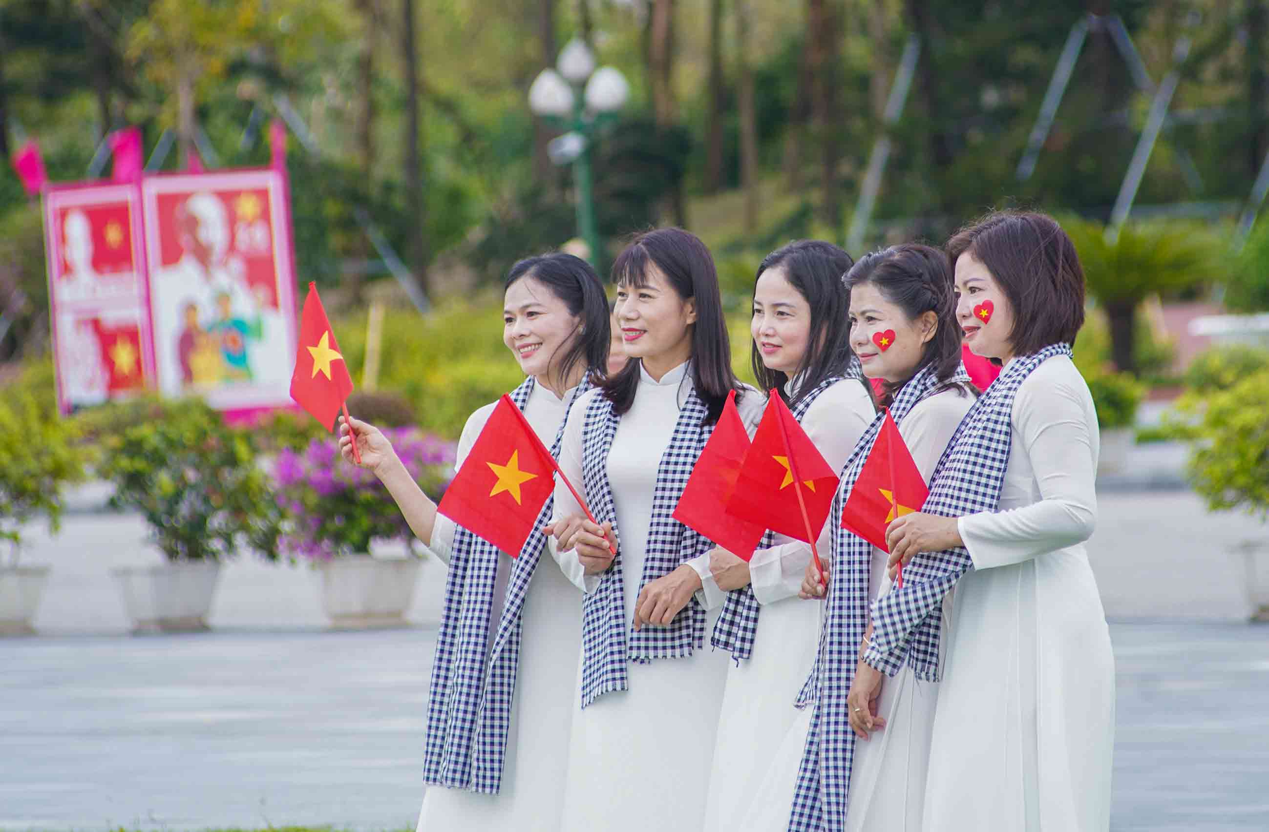 Trong ta ao dai truyen thong, nhieu chi em phu nu duyen dang cam tren tay nhung la co do sao vang, no nu cuoi rang ro truoc ong kinh. Anh: Duy Chuong