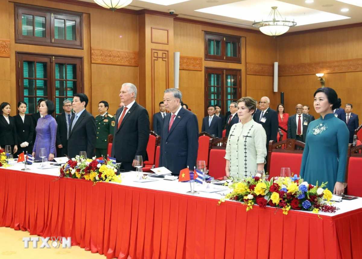 Cac dai bieu thuc hien nghi le chao co. Anh: TTXVN