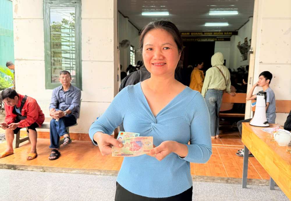 Moi cong dan co the mang chung minh thu den cac diem nhan qua o dia phuong de nhan 100.000 dong thay cho nguoi than trong gia dinh. Anh: Lam Hong