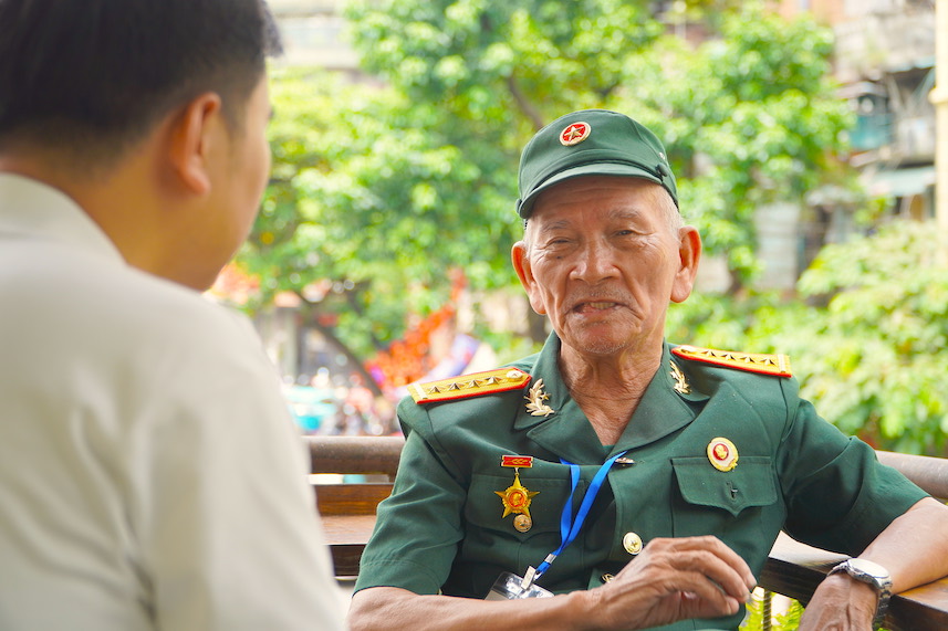Le soldat Tran Van Thanh raconte ses souvenirs sur le vieux champ de bataille. Photo : Journaliste