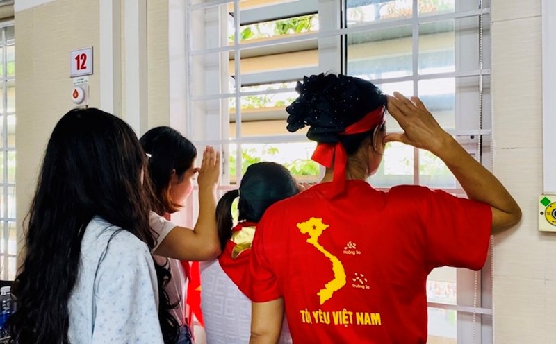 Saying goodbye to the flag, singing the national anthem through the window. Photo: Thuy Linh