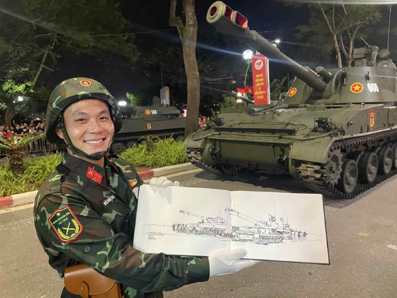 Đại úy Vũ Minh Trí - Bộ Tư lệnh Pháo binh Tên lửa chụp ảnh cùng bản kí họa chiếc xe pháo tự hành do họa sĩ người Philippines vẽ trong buổi hợp luyện diễu binh. Ảnh: Nhân vật cung cấp