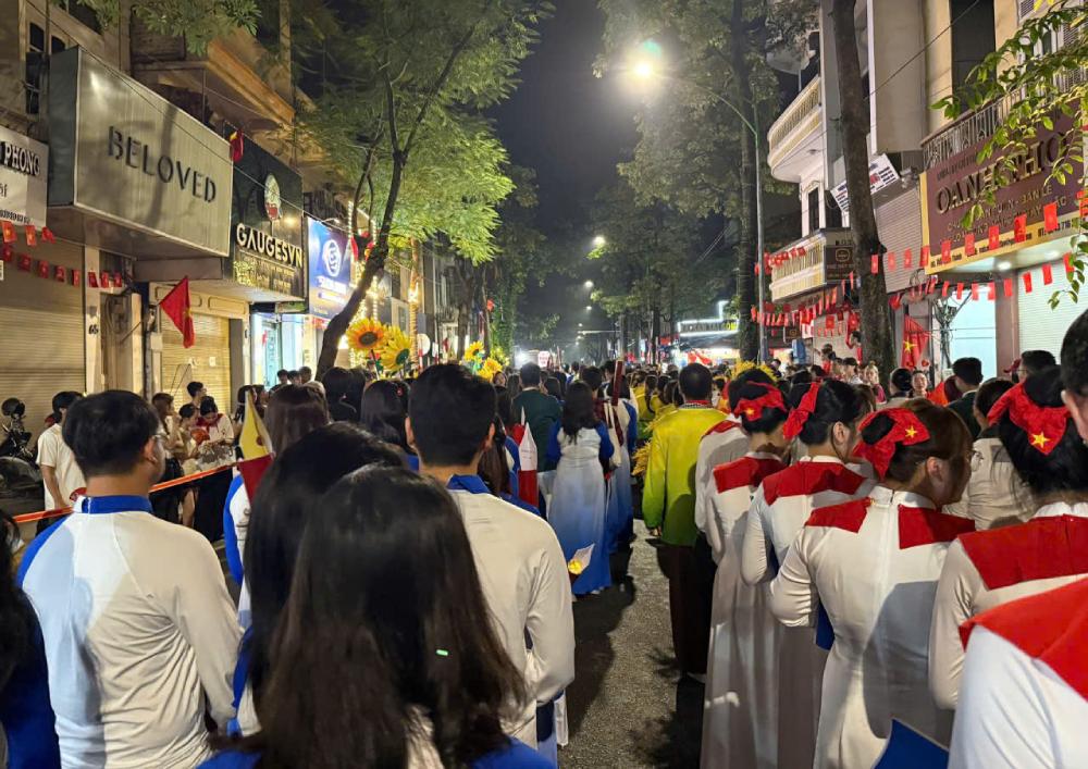 4h sang ngay 2.9, anh Tri va nhieu dong nghiep hoa chung dong nguoi ben duong pho trong ngay hoi lon cua non song, dat nuoc. Anh: Huu Tri