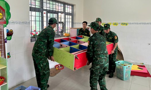 Cán bộ, chiến sĩ đồn Biên phòng Cửa khẩu cảng An Thới kê lại bàn ghế, vật dụng, dọn dẹp vệ sinh ở trường Mầm non An Thới. Ảnh: Tiến Vinh