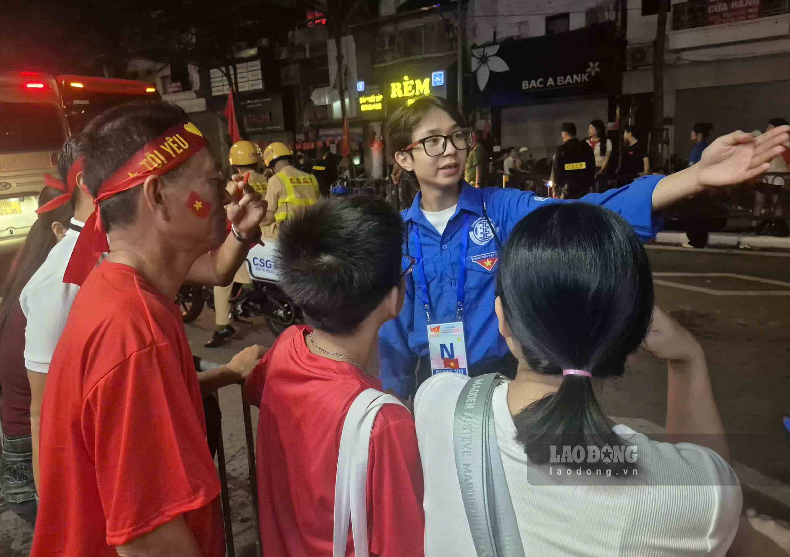Pham Dinh Van - 하노이 개방대학교 2학년 학생이 시민들에게 군사 퍼레이드 차량 행렬이 지나가는 도로로 이동하는 방법을 안내하고 있습니다. 사진: Tran Tuan