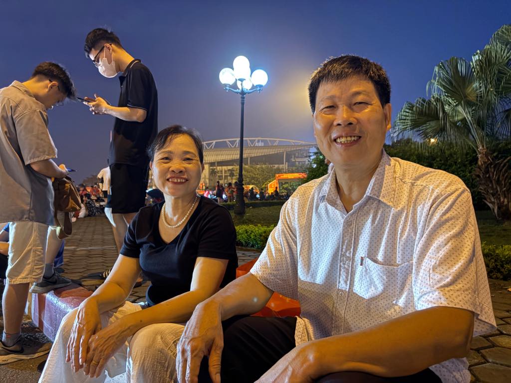 Mr. Hop and his wife waited to see military equipment. Photo: Bao Han