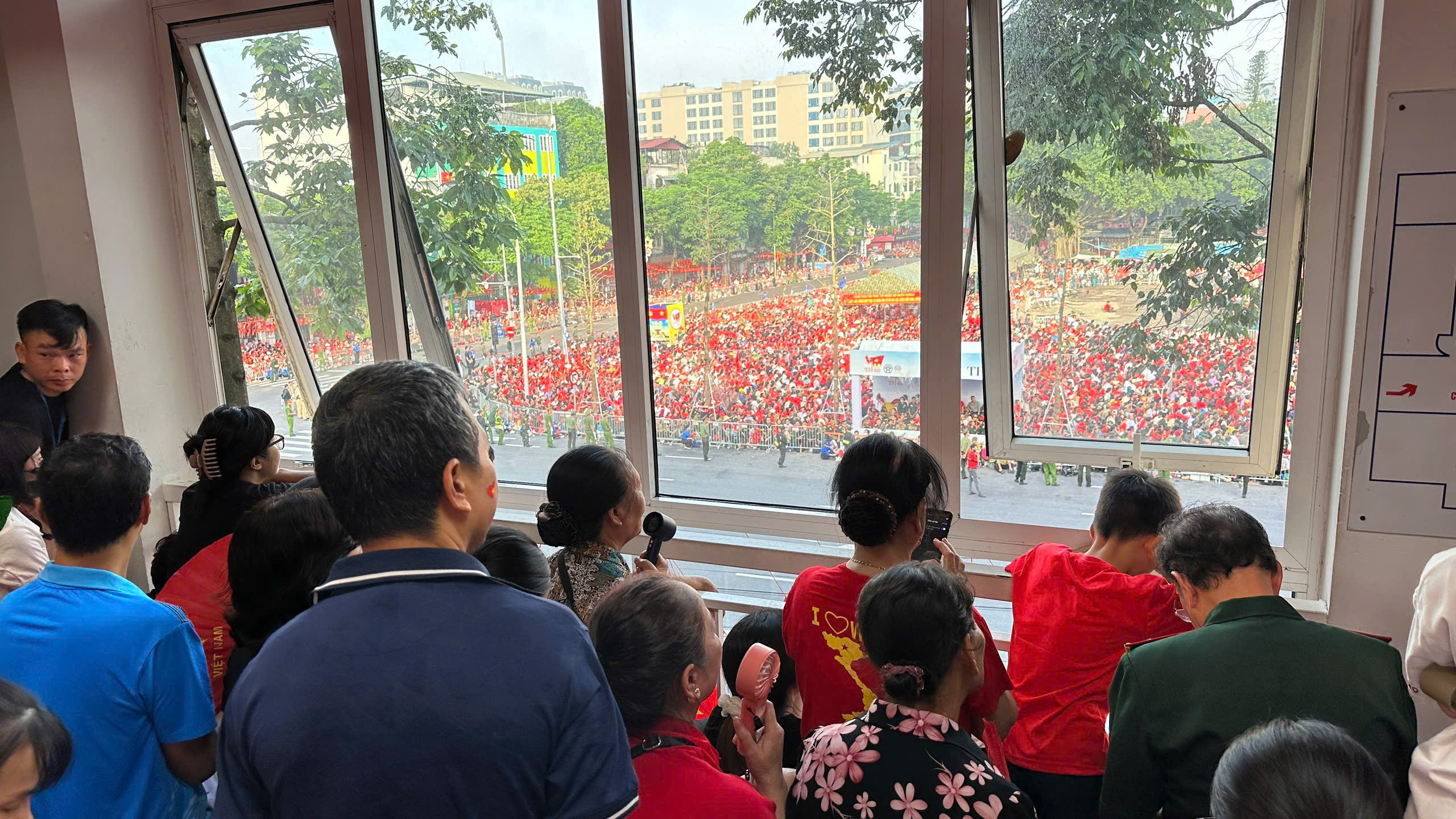 6h30:  Tai Benh vien Da khoa Xanh Pon, hang tram benh nhan va nguoi nha tu nhieu khoa phong deu huong mat ra o cua so de chung kien doan dieu binh, dieu hanh tren duong pho. Anh: Giang Linh