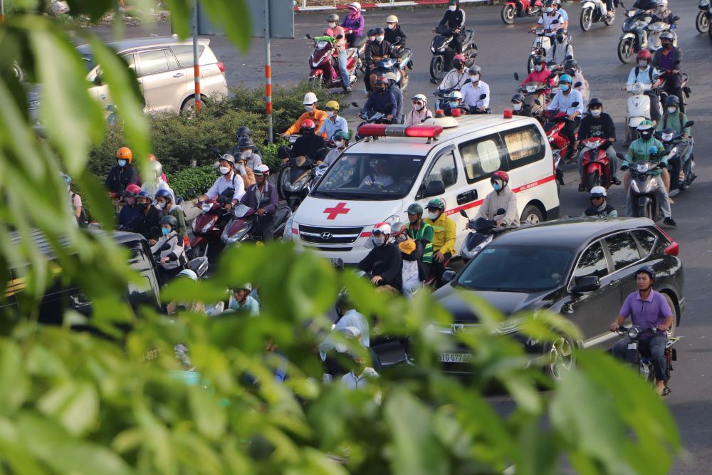 Mot chiec xe cuu thuong dang len loi trong dong phuong tien tren duong Quoc Lo 13, di chuyen theo huong tu Binh Duong cu vao trung tam TPHCM. Anh: Anh Tu