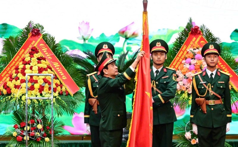 Authorized by the President, General Phan Van Giang - Politburo member, Minister of National Defense attaches the title of Hero of the People's Armed Forces to the traditional flag of the Government Cipher Committee. Photo: The Dai