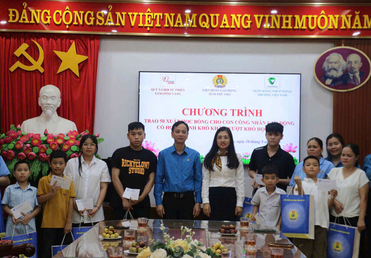 Tong Duc Chien 씨 - Phu Tho 지방 노동 연맹 상임 위원과 후원자 대표가 Hoa Binh 지역의 어려운 노동자 자녀에게 장학금을 수여하고 있습니다. 사진: Yen San