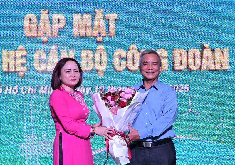 Ms. Nghiem Thuy Lan - President of the Vietnam National Industry - Energy Group Trade Union - presented flowers to express gratitude to former member of the Party Central Committee, former President of the Vietnam General Confederation of Labor Dang Ngoc Tung. Photo: Nam Duong