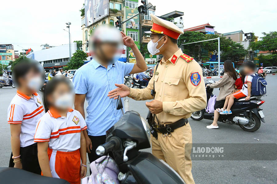 Mot truong hop khac bi to cong tac Doi CSGT duong bo so 3 xu ly. Phu huynh thi doi mu bao hiem, nhung 2 con thi khong. Mot hinh anh rat dang suy ngam.