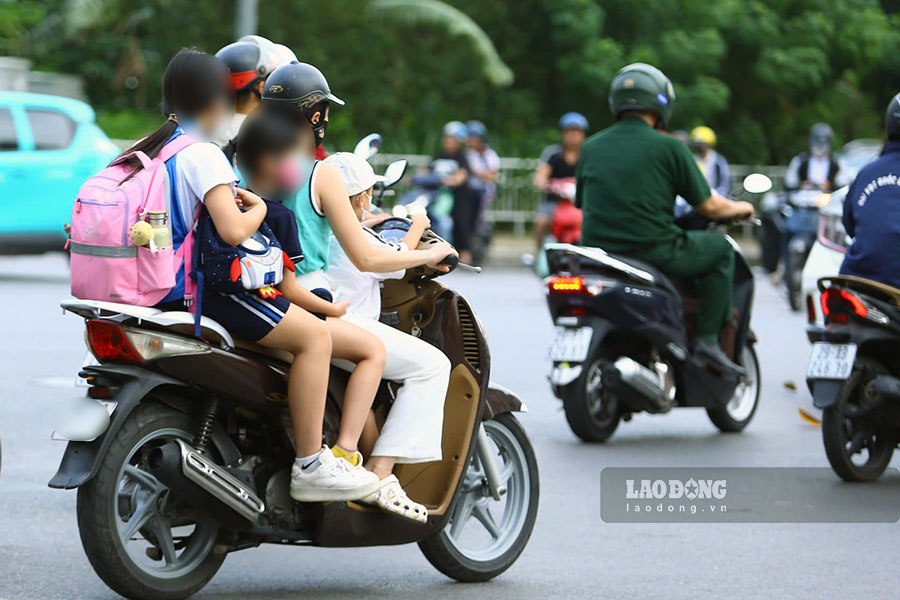 Ghi nhan cua PV trong sang 12.9, van con rat nhieu hinh anh nhu the nay dien ra - phu huynh cho con di hoc nhung vi pham Luat Giao thong duong bo khi khong doi mu bao hiem cho con.