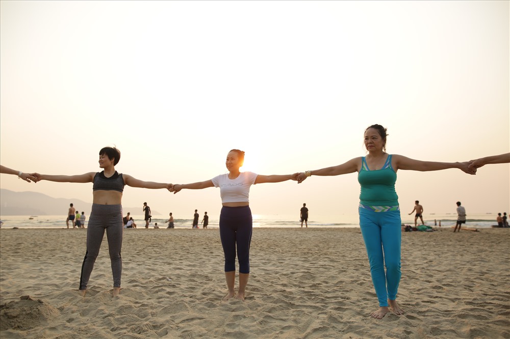 Da Nang people practice yoga on the beach. Photo: M.T.