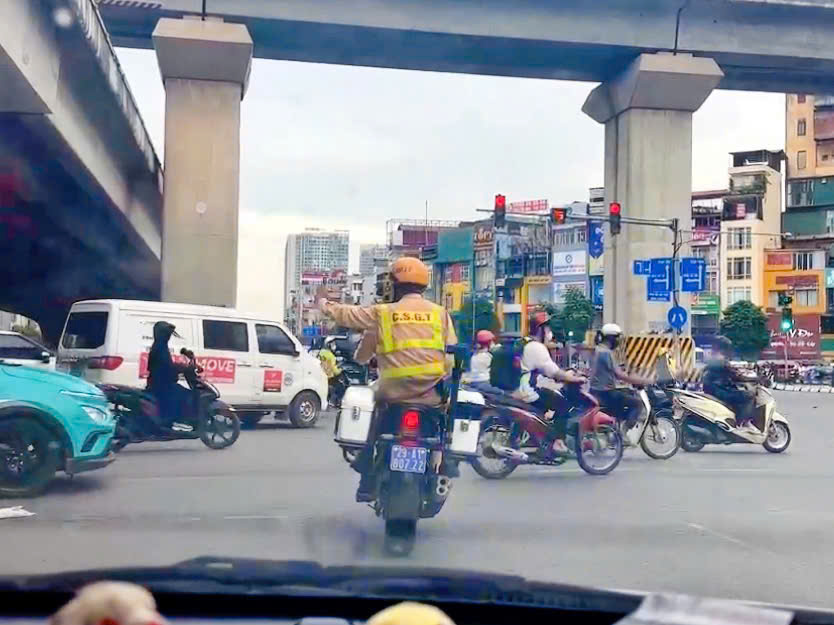 Hanoi Traffic Police paved the way to take the woman to the emergency room. Photo cut from clip