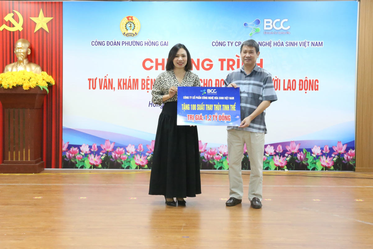 Chu tich Uy ban MTTQ phuong (ben phai) thay mat doan vien, nguoi lao dong phuong Hong Gai don nhan 100 suat thay thuy tinh the do Cong ty CP Cong nghe hoa sinh va Vien mat Alina trao tang. Anh: Cong doan phuong Hong Gai