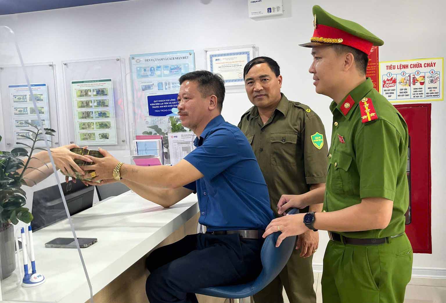 La policia presencio al Sr. Chien ir al banco para transferir y devolver 200 millones de VND a la persona que los transfirio por error. Foto: Policia de Thach Ha.