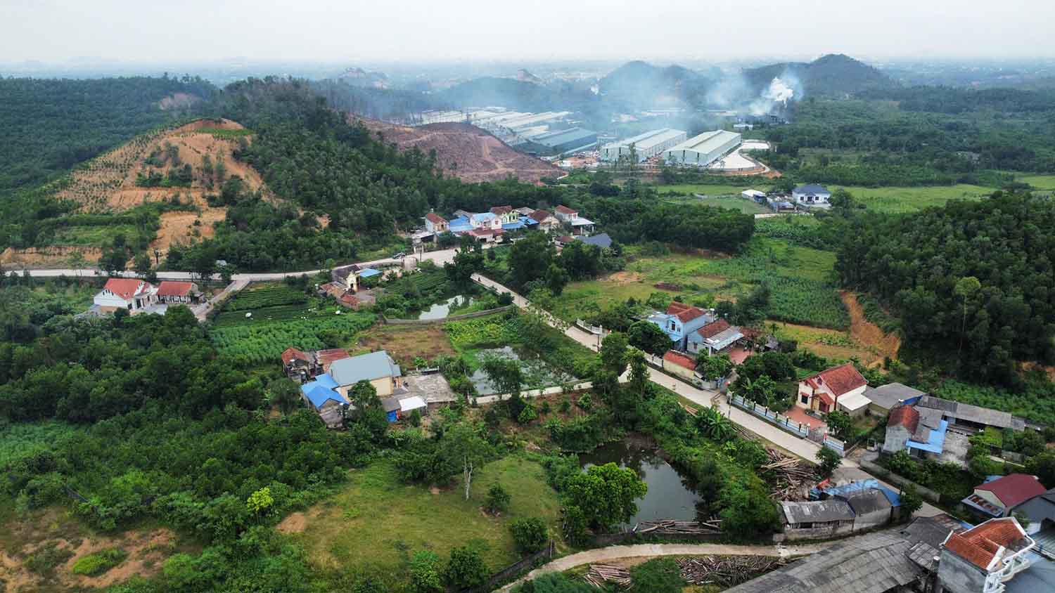 Cả trăm hộ dân sống rất gần các ống khói nhà máy xử lý rác sinh hoạt, rác công nghiệp nguy hại. Ảnh: PV