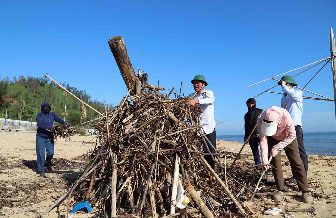 Collecting and treating garbage drifted to Thien Cam beach. Photo: Ngoc Long.