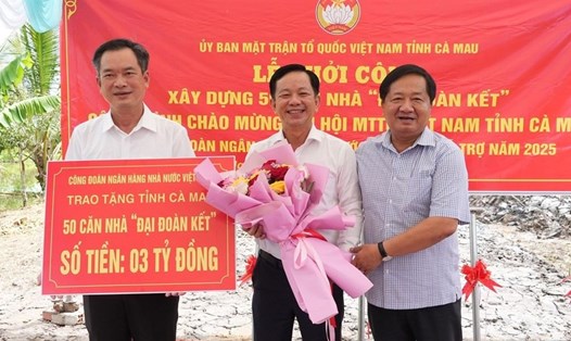 Phó Chủ tịch Thường trực Ủy ban MTTQ Việt Nam tỉnh Cà Mau Lê Thanh Triều (bìa phải) tặng hoa cho đại diện Công đoàn Ngân hàng Nhà nước Việt Nam. Ảnh: Kim Nhiên