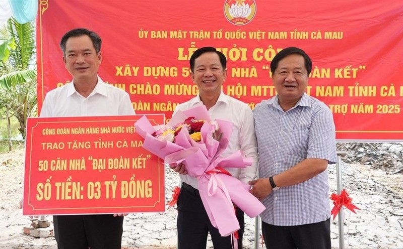 Permanent Vice Chairman of the Vietnam Fatherland Front Committee of Ca Mau province Le Thanh Trieu (right cover) presented flowers to the representative of the Vietnam State Bank Trade Union. Photo: Kim Nhien