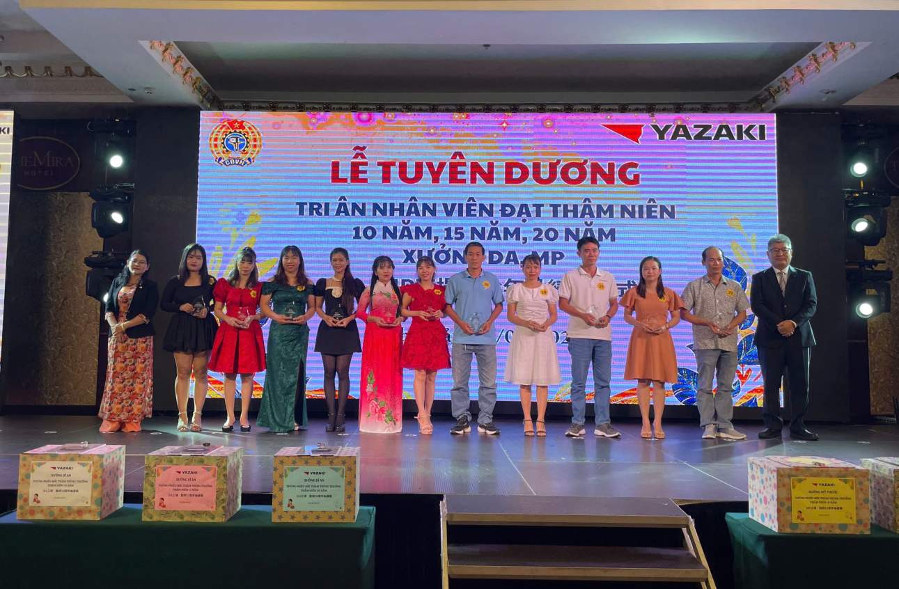Mr. NoGi Hiro Shi - General Director of Yazaki EDS Vietnam Co., Ltd. and Ms. Pham Thi Tuyet Nhung - Chairwoman of the company's Trade Union presented a plaque of gratitude to employees with 20 years of seniority. Photo: Dinh Trong