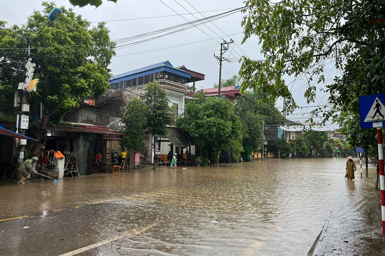 Luc luong chuc nang phuong Cam Duong, tinh Lao Cai cang day canh bao tuyen duong ngap lut. Anh: Cong an phuong Cam Duong