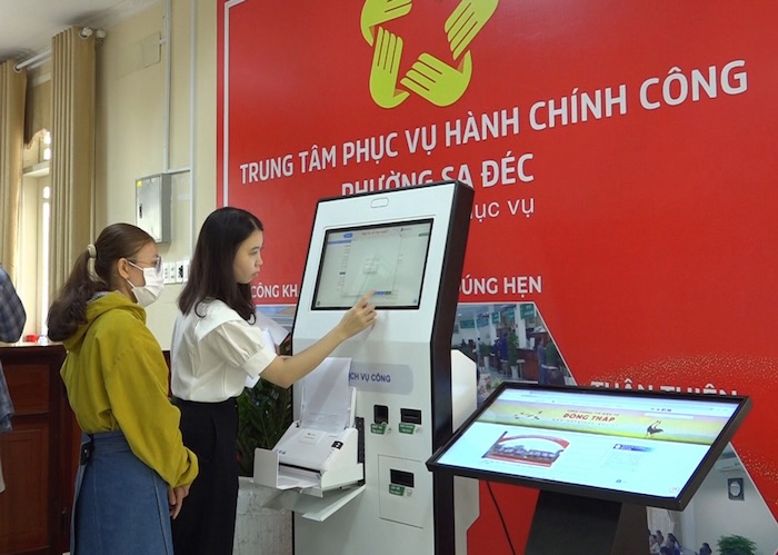 Cong chuc huong dan nguoi dan nop ho so truc tuyen tai ki-ot thong minh. Anh: Cong thong tin dien tu Dong Thap. 