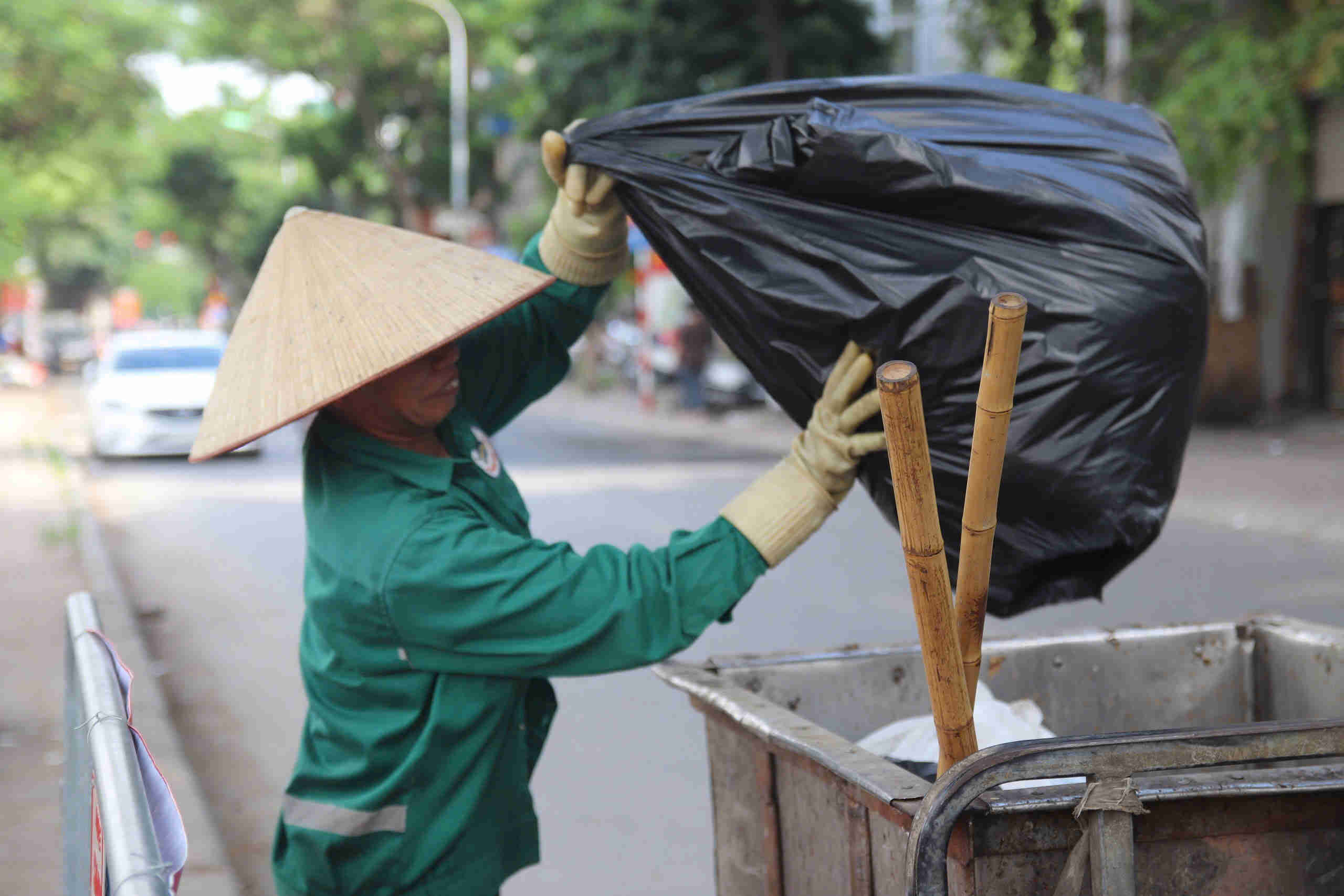 Ba Vu Thi Van phai om nhung tui rac nang do nguoi dan vut bua bai, khong dung noi quy dinh. Anh: Hoang Xuyen