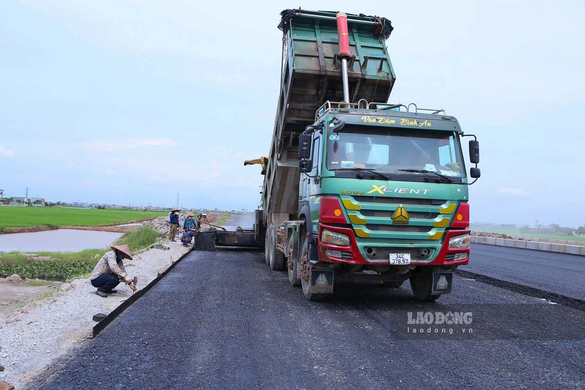 Cong nhan dang tham be tong nhua tai Km19+800 thuoc dia phan xa Xuan Truong. Anh: Luong Ha